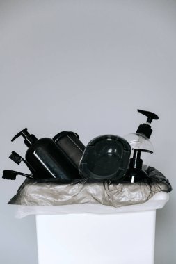 Çöpleri ayırmak için sepetteki farklı sıvıların altındaki siyah boş plastik şişeler. Atık geri dönüşümü, atık ayıklama ve plastiği durdurma kavramı