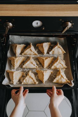 Kız fırına turta dolu bir yemek tepsisini itiyor. Ulusal yemek