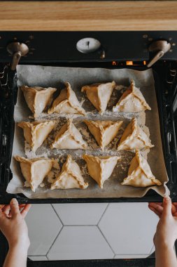 Kız fırına turta dolu bir yemek tepsisini itiyor. Ulusal yemek