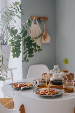 Çilekli ve muzlu Viyana waffleları. Beyaz bir masada güzel bir kahvaltı