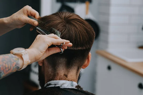 Corte de cabelo dos homens em casa. O cabeleireiro corta o cabelo de um homem — Fotografia de Stock