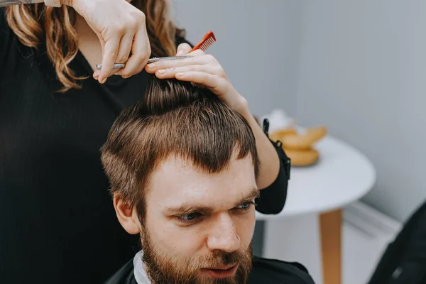 Fryzura męska w domu. Fryzjer obcina włosy mężczyźnie. — Zdjęcie stockowe