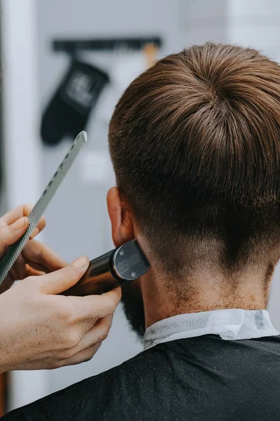 Coupe de cheveux pour hommes à la maison. Le coiffeur coupe les cheveux d'un homme — Photo