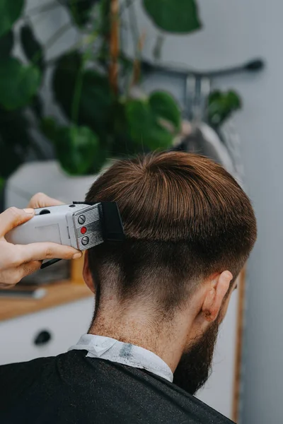 Mens haircut at home. The hairdresser cuts the hair of a man