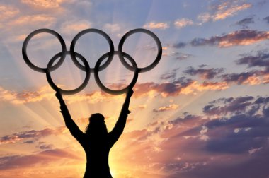 Atlet holding olimpik halka günbatımı