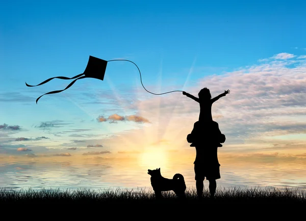 Молодий тато з дитиною і собакою грає з повітрям біля моря — стокове фото