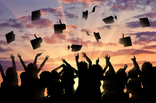 Випускники захід сонця кидають шапку випускників — стокове фото