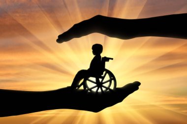 Adamın elinde bir tekerlekli sandalyede engelli çocuk