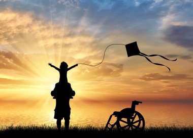 Uçurtma ve tekerlekli sandalye deniz günbatımı yakınındaki oynamaya babamın omuzlarında engelli çocuk