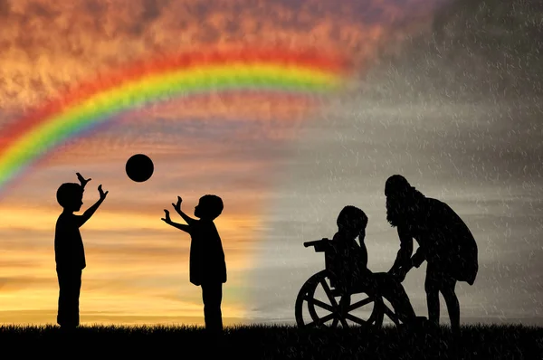 Postižené dítě ve vozíku pláč a jeho matka děti hrají s míčem — Stock fotografie