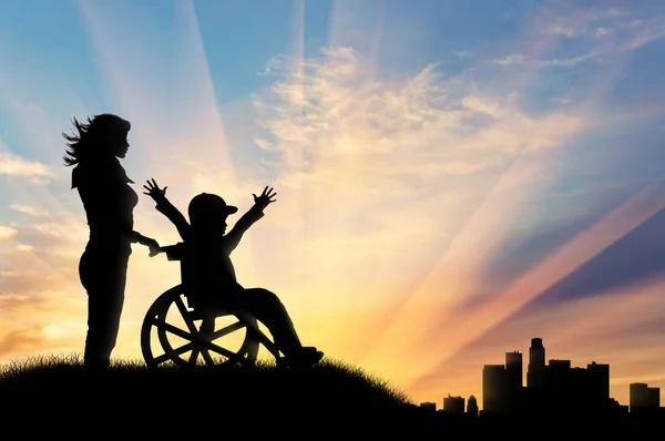 Lycklig pojke i rullstol och sjuksköterska på sunset nära stan — Stockfoto