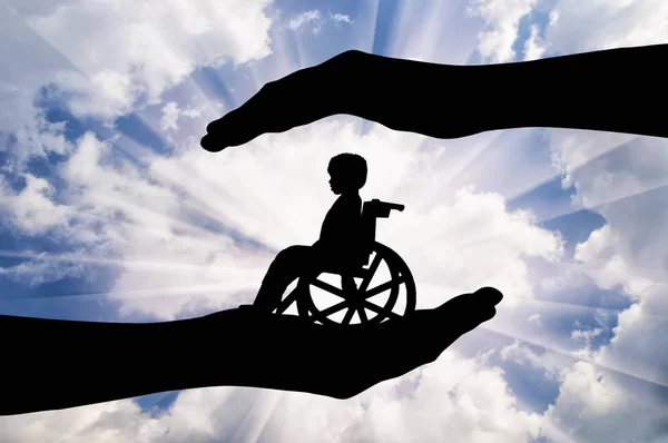 Ребенок-инвалид в инвалидном кресле в руках мужчины — стоковое фото