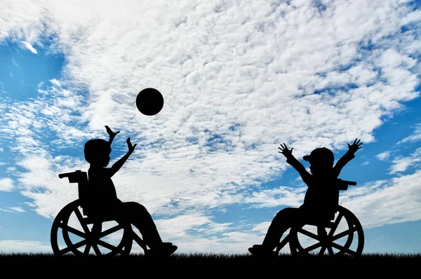 Crianças felizes deficiências em cadeira de rodas jogar bola dia — Fotografia de Stock