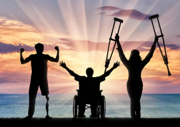 Glücklich drei Behinderte und Meer Sonnenuntergang — Stockfoto