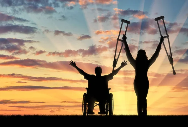 Feliz invalida con muletas y en silla de ruedas puesta de sol —  Fotos de Stock