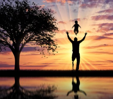 Bebekle oynarken onun bacak protezi ile engelli kişi