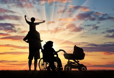 Özürlü tekerlekli sandalye ve çocuk arabası ve aile günbatımı