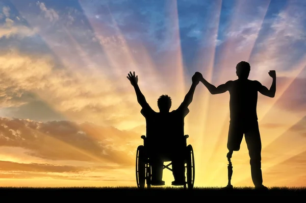 Discapacitados con prótesis y en silla de ruedas cogidos de la mano puesta de sol —  Fotos de Stock