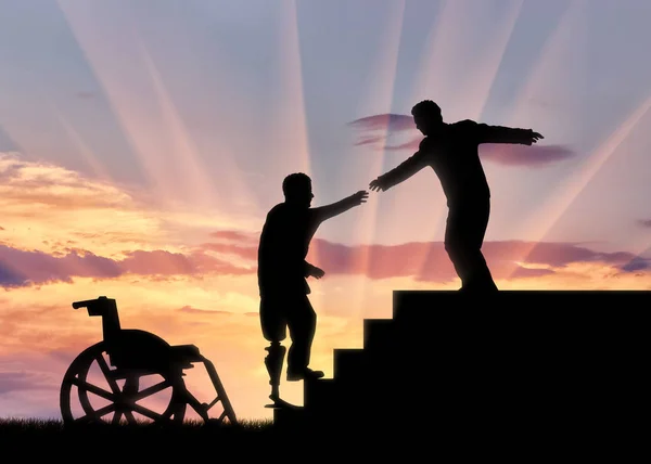 Мужчина помогает инвалиду с протезом на лестнице на закате — стоковое фото