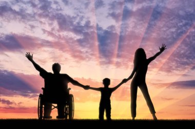 Tekerlekli sandalye ve gün batımı arka plan üzerinde mutlu aile Engelli