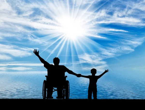 Handicapée en fauteuil roulant avec son fils par la mer happy day — Photo