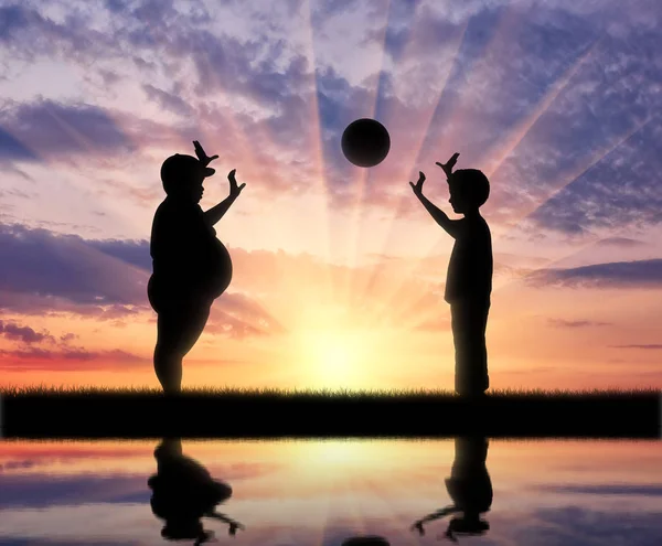 Gordo chico y normal jugar pelota y reflejo en el agua — Foto de Stock