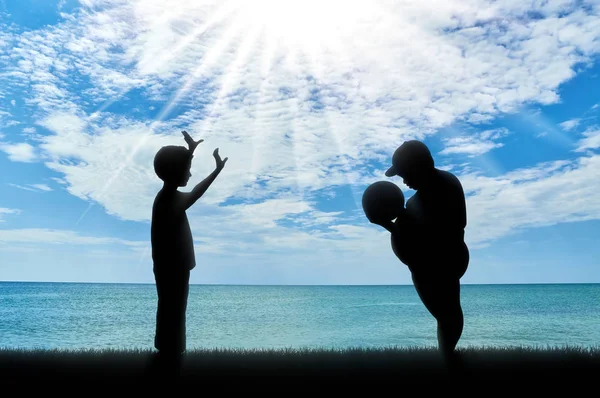 Normaler und dicker Junge, der tagsüber Ball auf See wirft — Stockfoto