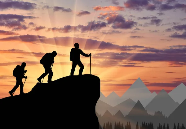Альпинисты силуэта, поднимающиеся на вершину горы — стоковое фото