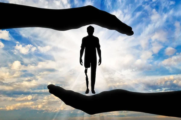 Vammainen henkilö, jolla on proteettinen jalka miehen käsissä — kuvapankkivalokuva