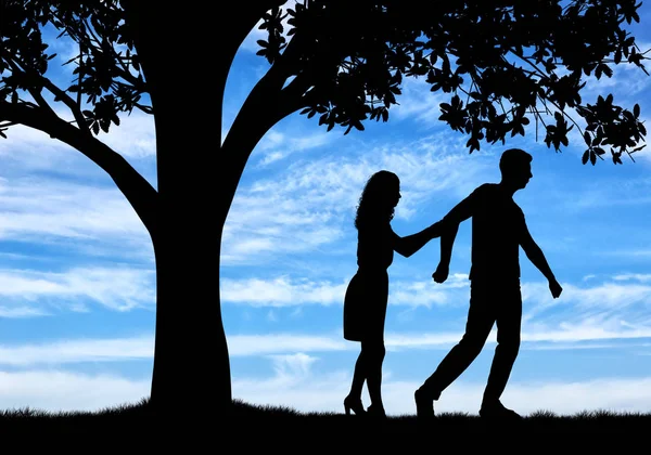 Silhouette of a man throwing a woman near a tree — Stock Photo, Image