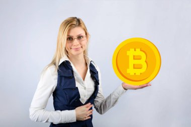 Bir kadın gözlük bir bitcoin elinde tutar.