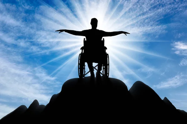 Silueta de hombre discapacitado feliz en silla de ruedas en la cima de la montaña — Foto de Stock