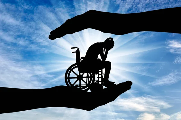 Silhouette of sad disabled woman in wheelchair in hands of help — Stock Photo, Image