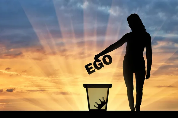 Silhouet van een vrouw gooit het woord ego in de vuilnisbak — Stockfoto