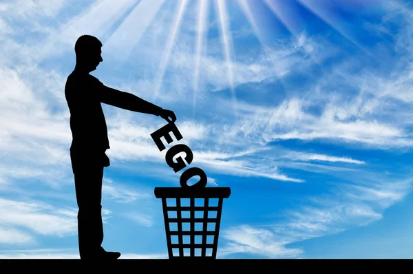 Silhouette of a man throws the word ego into the garbage bin