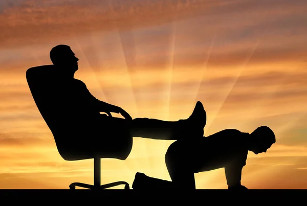 Силуэт эгоистичного человека, сидящего в кресле, откидывающего ноги назад на спину человеку — стоковое фото