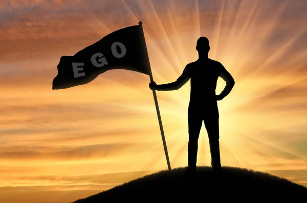 Silhouet van een egoïstische man met een kroon op zijn hoofd heeft een vlag met het woord ego op de top van een heuvel — Stockfoto