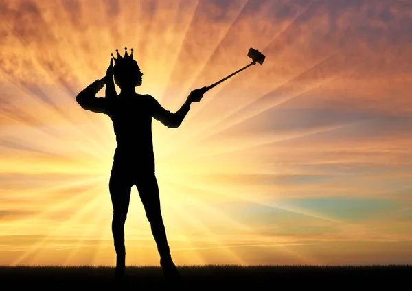 Una silhouette di una donna narcisista ed egoista con una corona in testa, fa selfie al telefono — Foto Stock