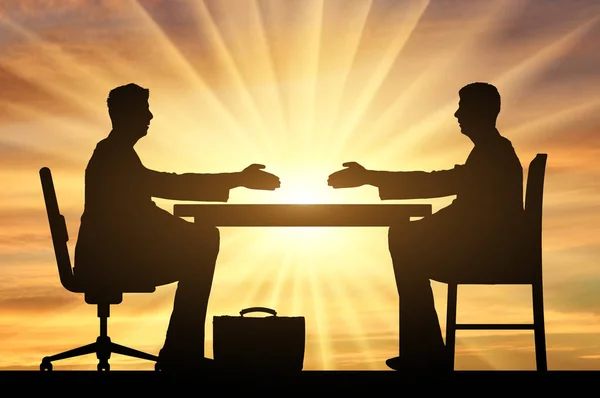 Concept wervingsproces. Silhouet van twee mannen aan een tafel die hun handen uitstrekken voor een handdruk — Stockfoto