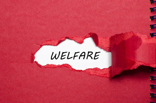 La parola welfare appare dietro la carta strappata — Foto Stock