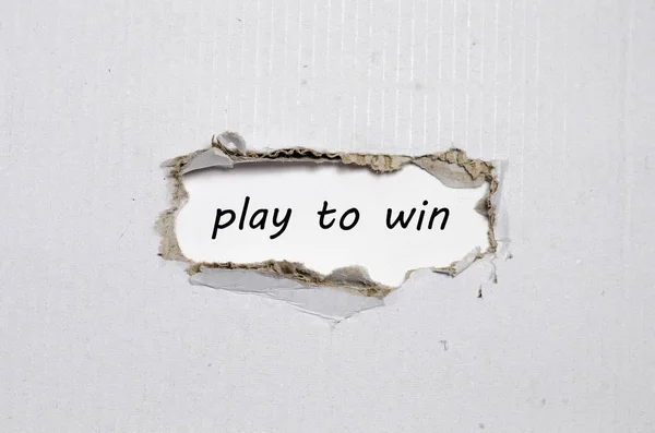 Het woord spelen om te winnen wordt weergegeven achter gescheurd papier — Stockfoto