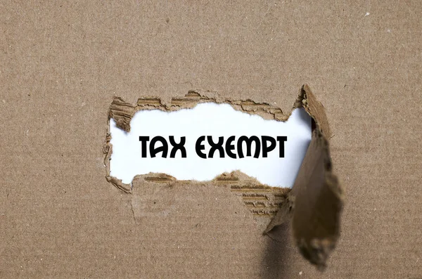 A palavra isenção de imposto que aparece atrás do papel rasgado — Fotografia de Stock