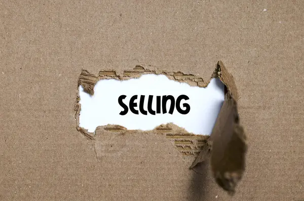 The word selling appearing behind torn paper — Stock Photo, Image
