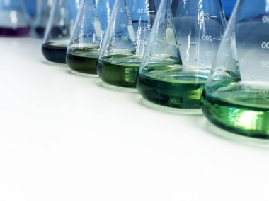 Atık su örneğinde borik asit ve amonyak çözeltisi konsantrasyonu arasında reaksiyon oluşumundan kaynaklanan yeşil çözücü içeren, bank laboratuvarındaki Erlenmeyer veya Conical matarası. Seçici odak.