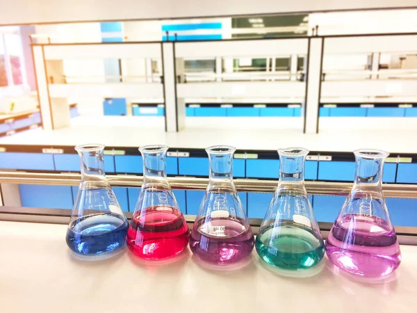 Colorful indicator in Erlenmeyer flask for titration experiment in environmental health laboratory. Science chemistry laboratory background