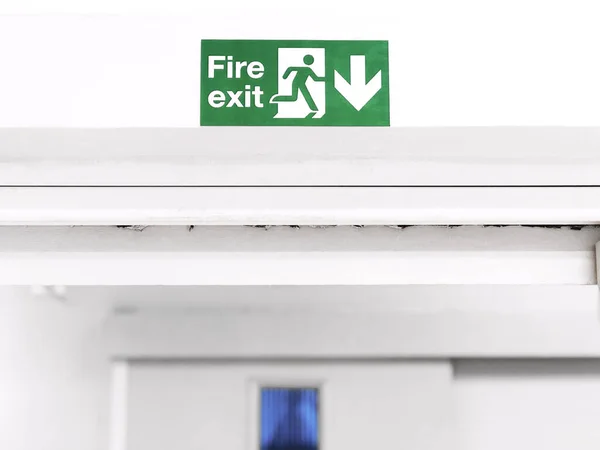 Fire Exit sign on the wall entry the room, green safety symbol icon isolated in the white door. Caution for warning in dangerous fire situation, Risk assessment management safety workplace concept.