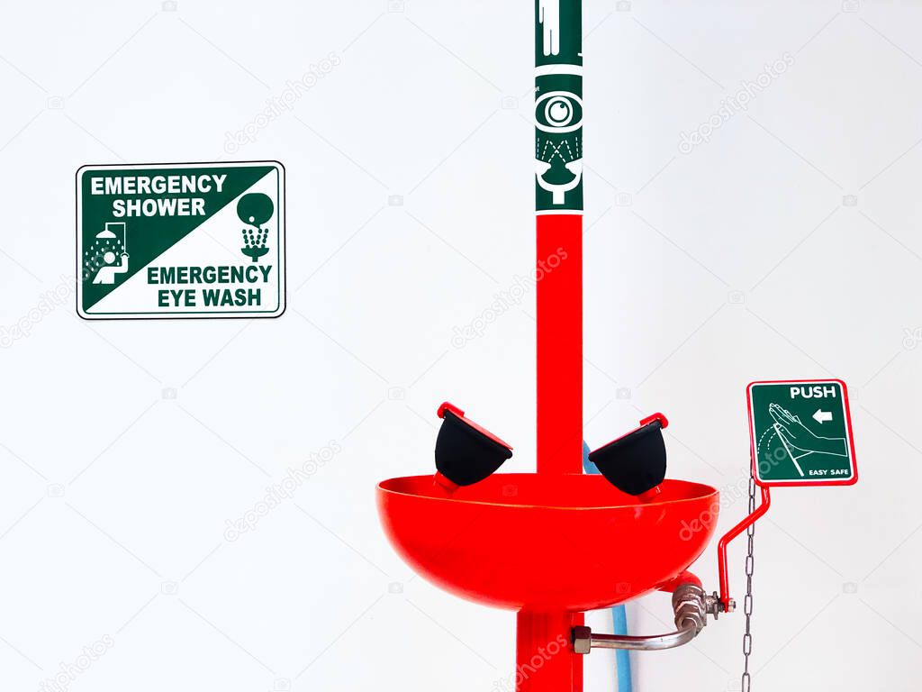 Eye wash station and push on button for flowing the water washing eyes, when touch with Acid or toxic chemical, safety first protection equipment in chemistry laboratory. Isolated in white background.
