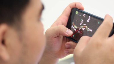 Muang, Phitsanulok / Tayland - 22 Mayıs 2020: Şişman küçük çocuk akıllı telefondan oyun bağımlılığı problemleri ile çevrimiçi oyun oynuyor..