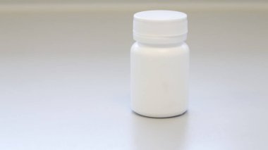 Beyaz ilaç şişesi veya kavanozu beyaz tıbbi oda arka planında izole edilmiş kapak şablonu, ilaç hapları, haplar, kapsüller, ilaç vitaminleri veya vitamin takviyeleri için ilaç paketleri.