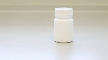 Beyaz ilaç şişesi veya kavanozu beyaz tıbbi oda arka planında izole edilmiş kapak şablonu, ilaç hapları, haplar, kapsüller, ilaç vitaminleri veya vitamin takviyeleri için ilaç paketleri.